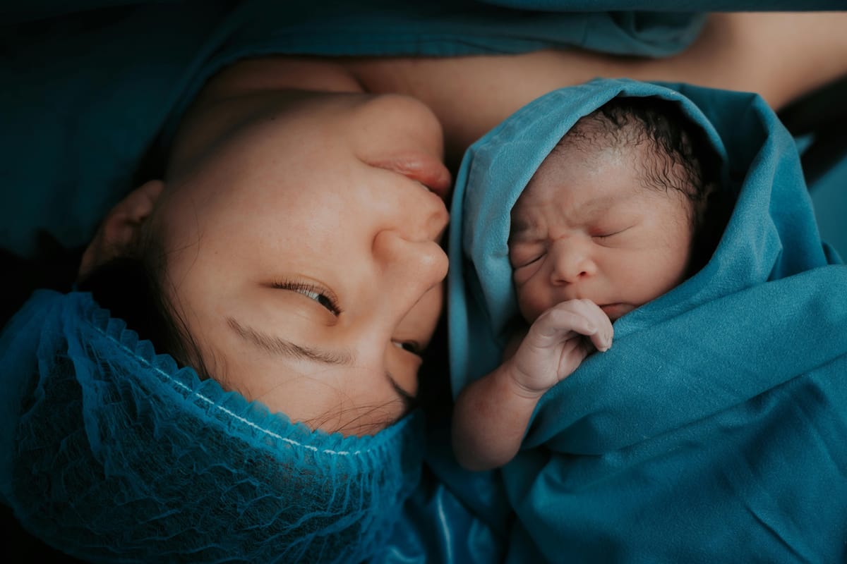 A mother looking at her newborn baby